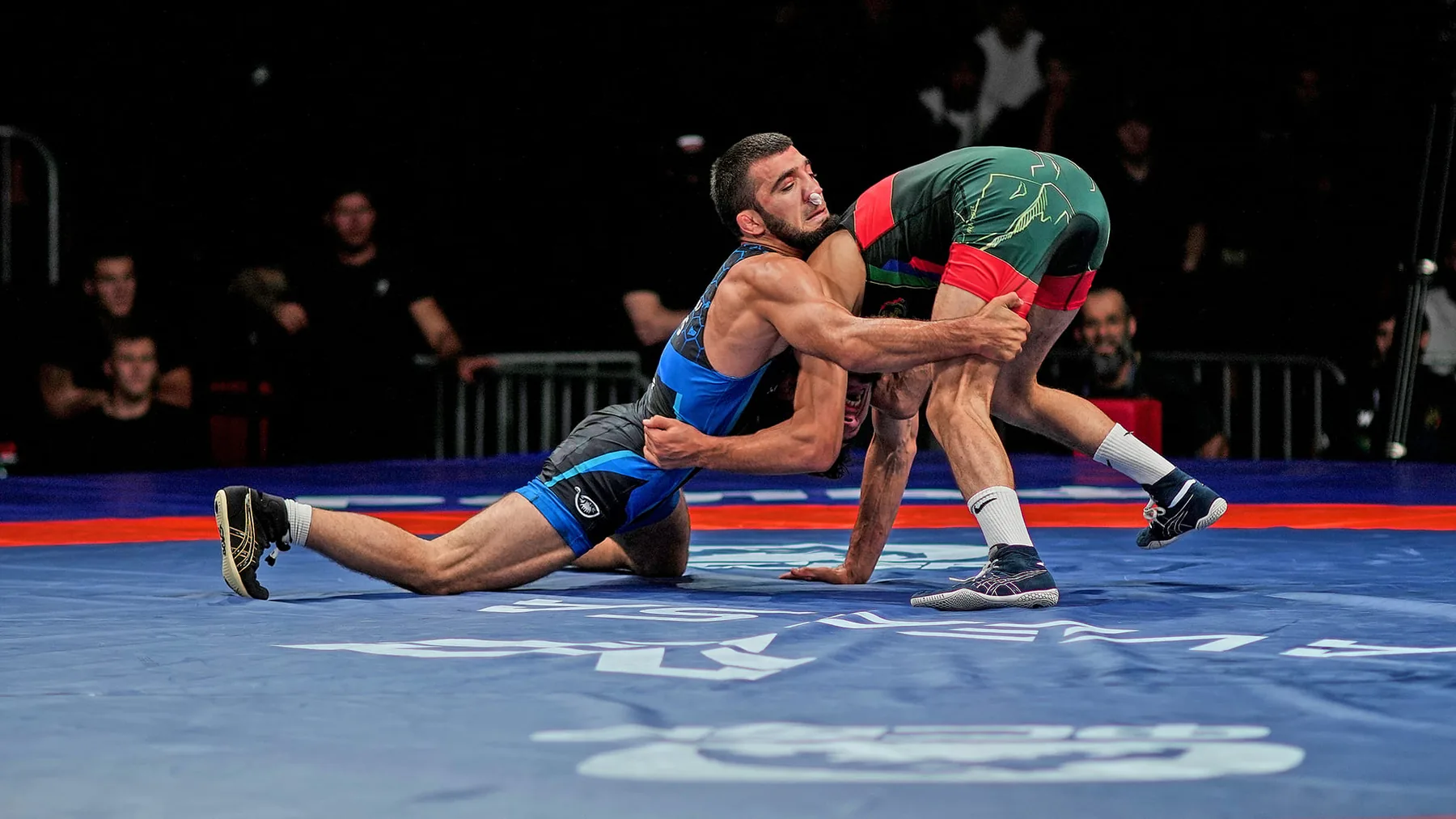 Two athletes competing in freestyle wrestling